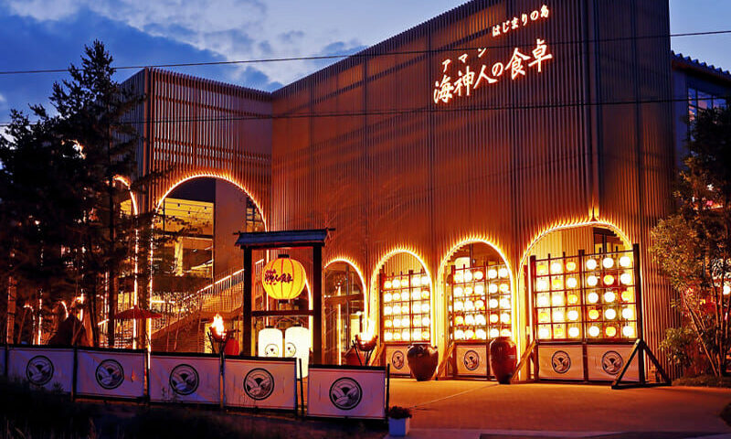 The beautifully illuminated exterior of Aman no Shokutaku restaurant on Awaji Island, glowing at night.