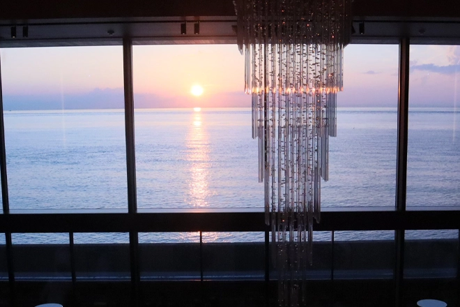 Sunset ocean view from Aonoya on Awaji Island with warm light reflecting over the sea through a large window.