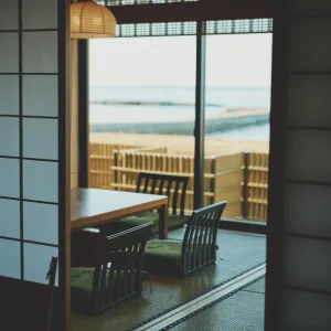 Traditional tatami room with shoji doors, low table, and water view at a luxury Japanese ryokan with private onsen on Awaji Island.