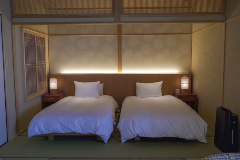 Japanese‑style twin bedroom with tatami flooring, soft ambient lighting, and minimalist design at a luxury ryokan with private onsen on Awaji Island.