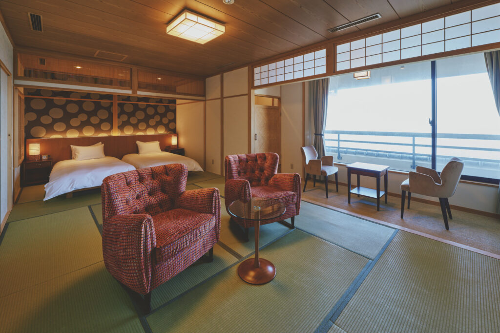 Deluxe Japanese-style ryokan room on Awaji Island with tatami flooring, semi-double beds, ocean view seating area and cypress bath overlooking the Seto Inland Sea