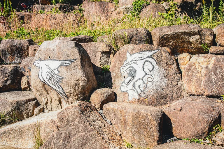 White rock painting with bird and dragon symbols at Naruto Boruto attraction in Nijigen no Mori Awajishima