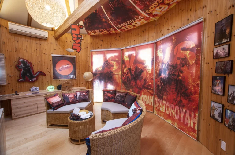 Godzilla themed room at Grand Chariot Awaji Island with large windows, themed décor, sofas with Godzilla pillows