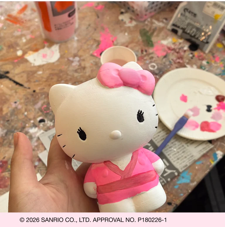 painting a Hello Kitty pottery figure during hands-on workshop experience