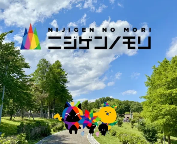 An outdoor pathway winding through a lush green park on Awaji Island, featuring the colorful "Nijigen No Mori" logo and playful cartoon characters superimposed against a bright blue sky with white clouds.