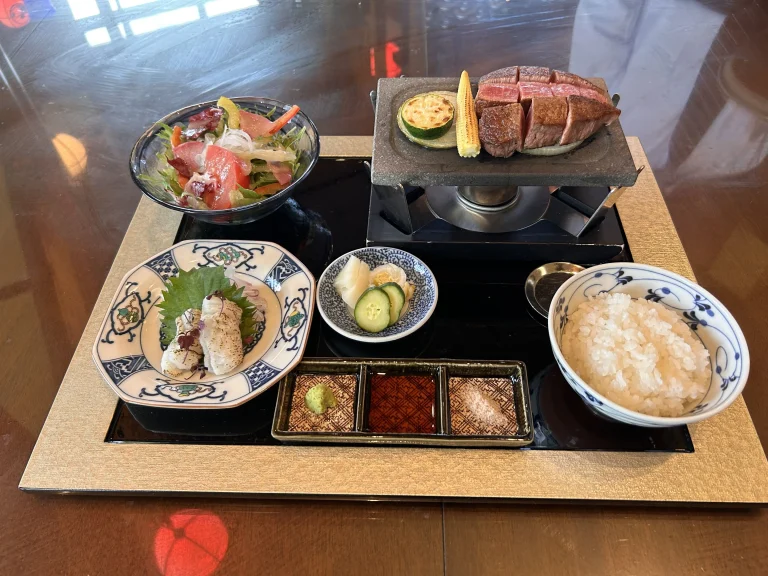 A complete meal set at Aman no Shokutaku Sajiki featuring grilled wagyu beef, fresh rice, salad, and seasonal vegetables.